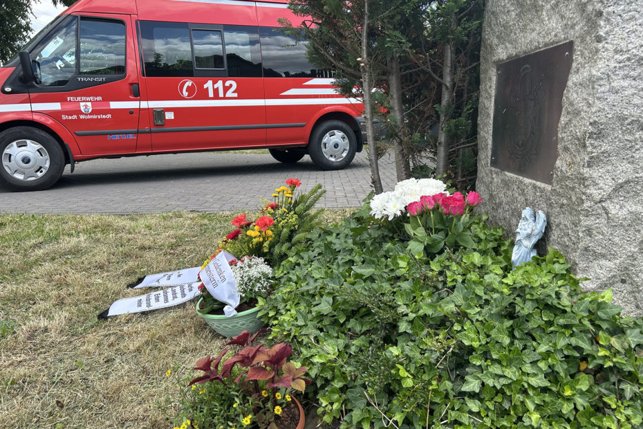 Gedenkstein mit Feuerwehr im Hintergrund