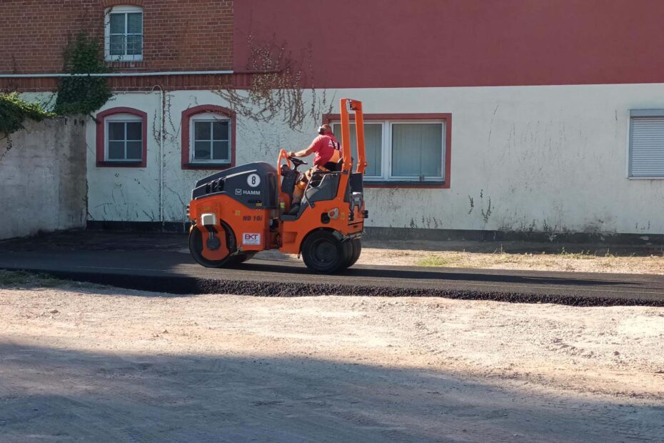 Mitarbeiter einer Fachfirma bauen Asphalt ein