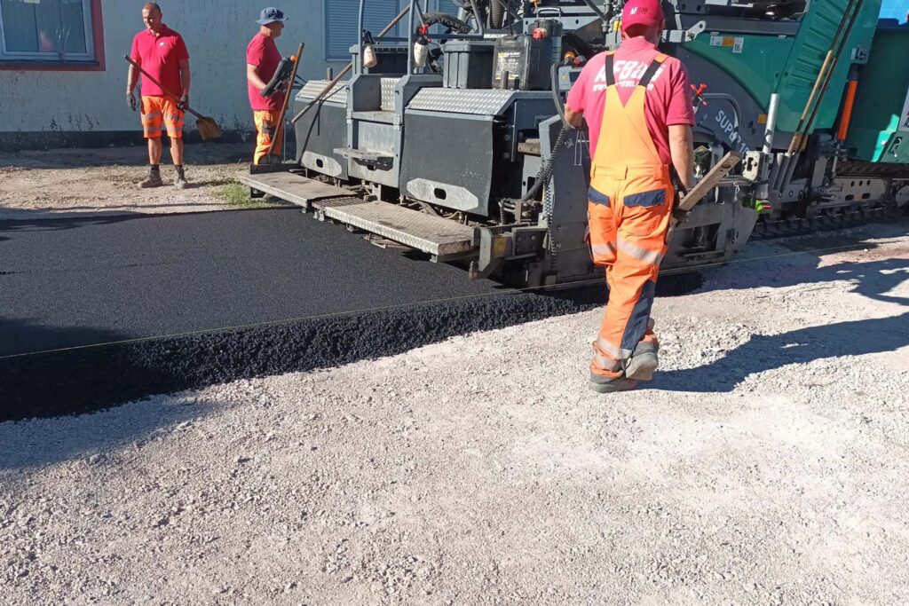 Employees of a specialist company lay asphalt