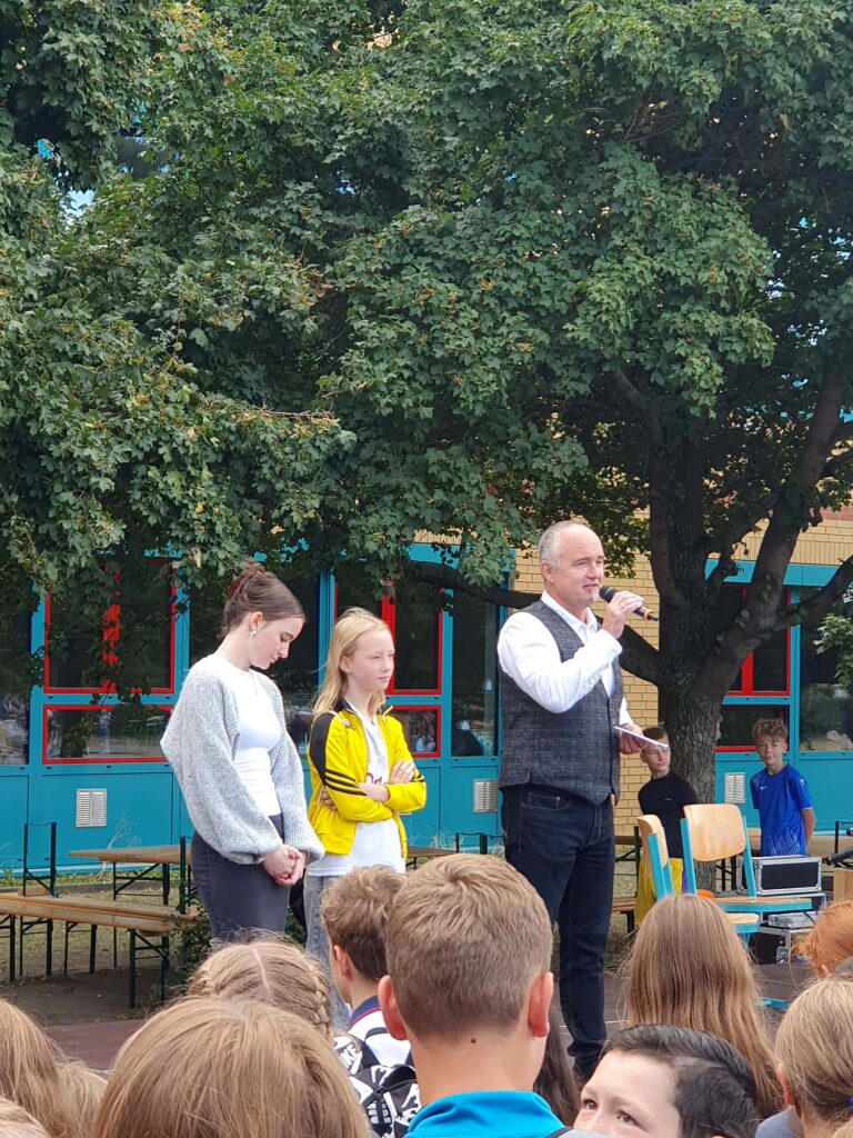 Principal Carsten Koslowski and pupils on stage at the ceremony.