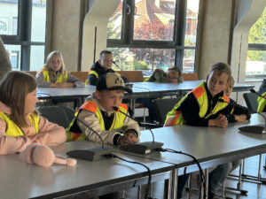 Die Jungen und Mädchen probieren die Mikrofone im Ratsaal aus.
