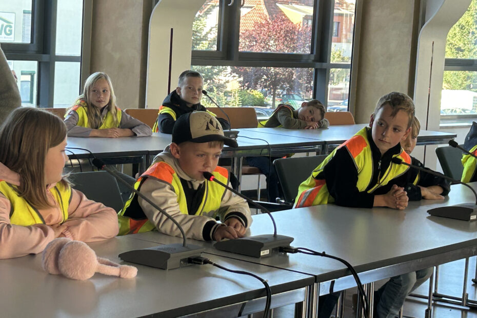 Die Jungen und Mädchen probieren die Mikrofone im Ratsaal aus.