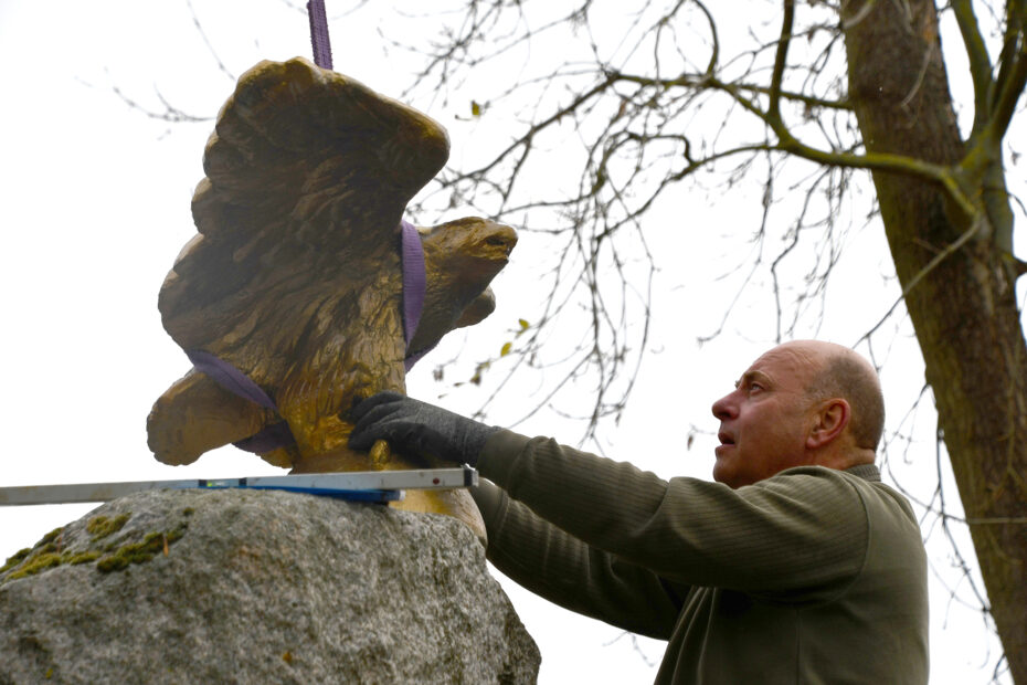 Restaurator Oliver Guhr befestigt den Adler auf dem Denkmal.