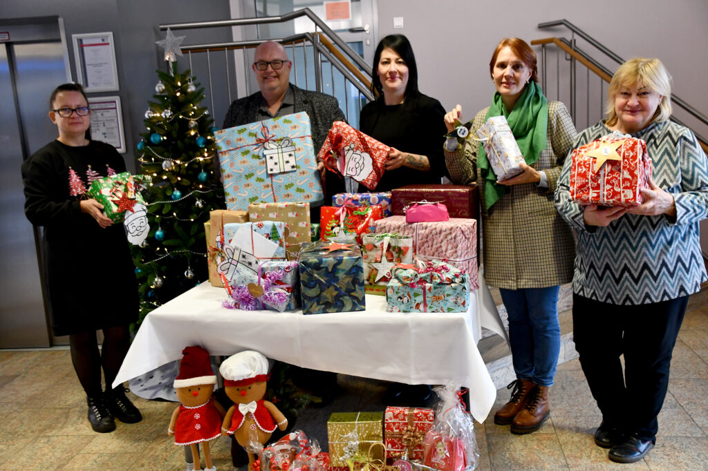 Mitarbeiterinnen der drei verschiedenen Einrichtungen bekommen die Geschenke der Wunschbaumaktion von Bürgermeister Mike Steffens überreicht.