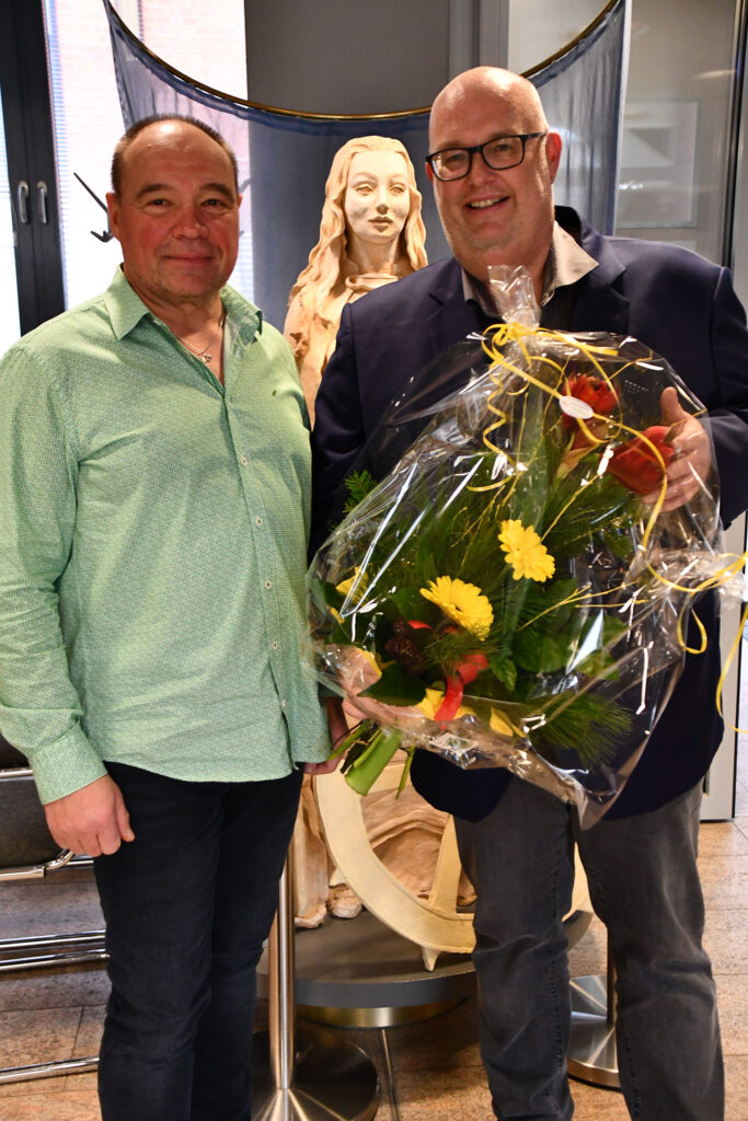 Wolmirstedts stellvertretender Bürgermeister Jens Sonnabend überreicht dem neuen Bürgermeister Mike Steffens an dessen erstem Arbeitstag Blumen.