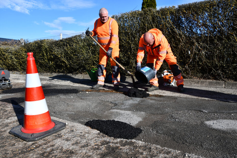 Mitarbeiter des Bauhofs der Stadt Wolmirstedt verfüllen Schlaglöcher auf dem Lindhorster Weg