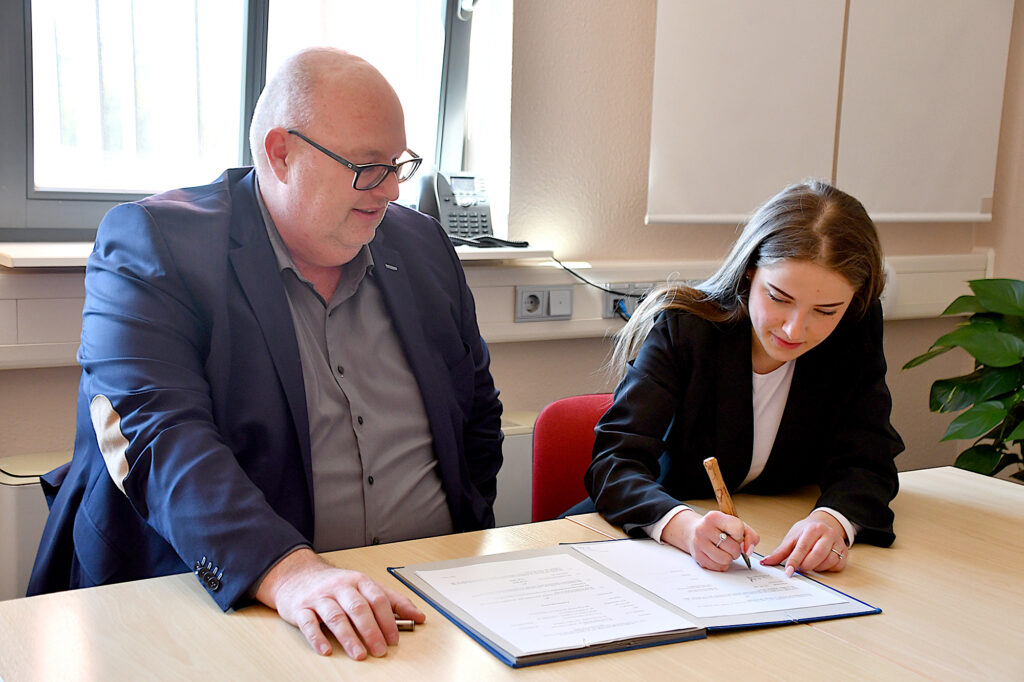 Wolmirstedts Bürgermeister Mike Steffens und Helene Hilma Schostock aus Colbitz unterzeichnen den Ausbildungsvertrag.