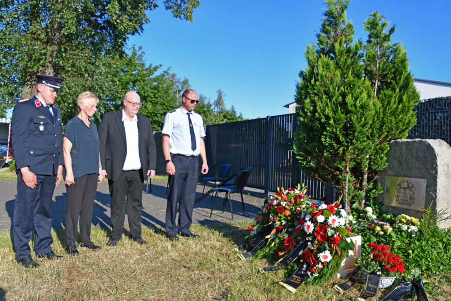 Kränze und Blumen am Gedenkstein