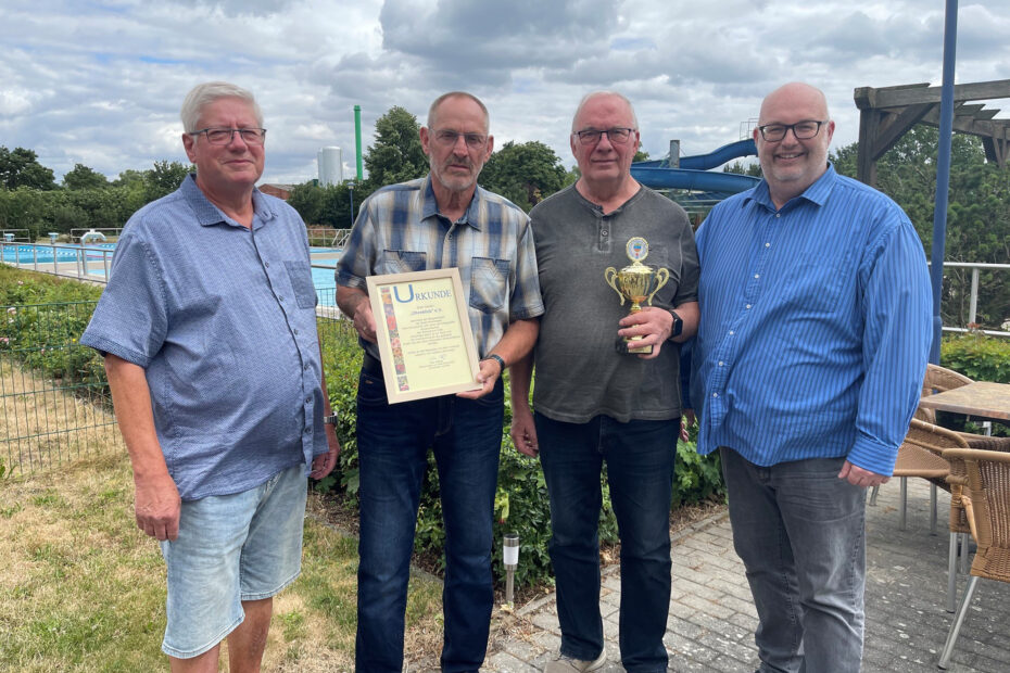 Bürgermeister Mike Steffens übergibt einen Pokal an den Kleingartenverein Ohreblick.