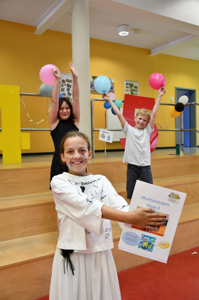 Mia Sofie, Mathilda und Brian haben ihre Abschlusszeugnisse für die 4. Klasse in der Diesterweg-Grundschule erhalten